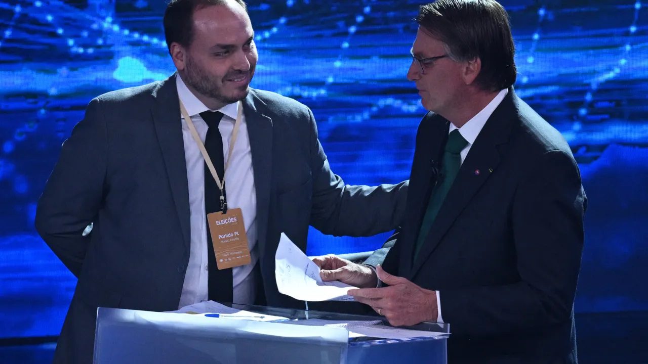 Carlos e Jair Bolsonaro durante o debate da Band - Nelson Almeida_AFP